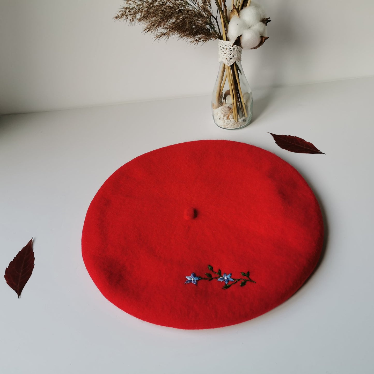 Beretă de lână roşie cu ramură de flori