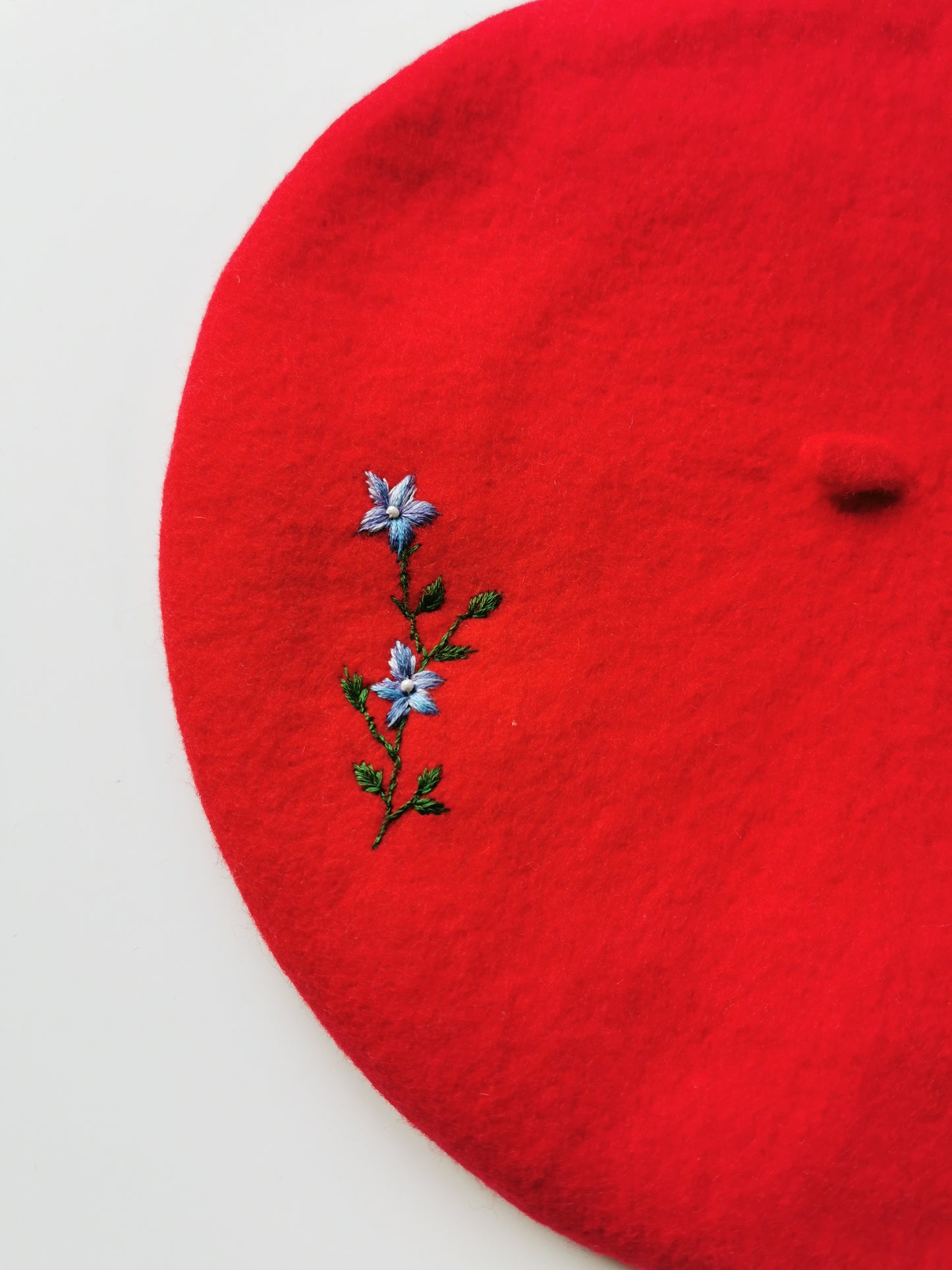 Beretă de lână roşie cu ramură de flori