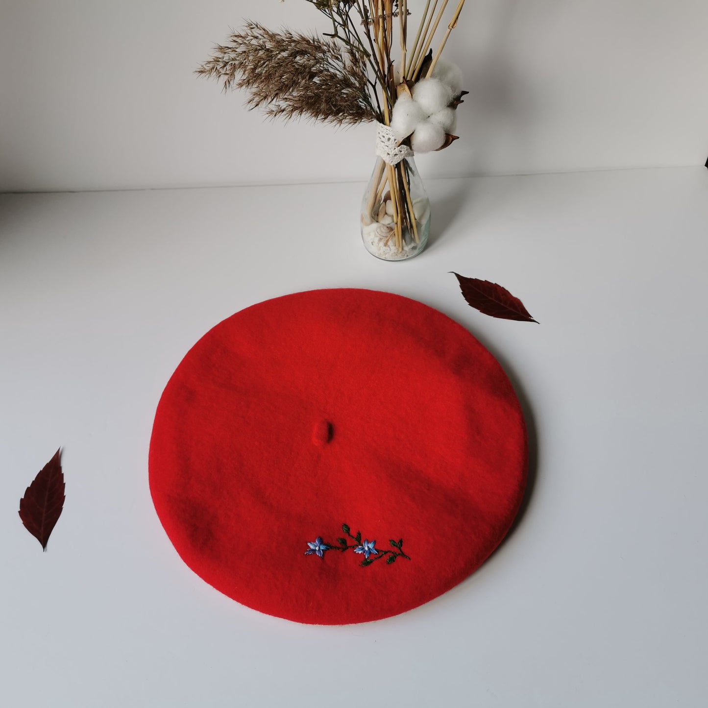 Beretă de lână roşie cu ramură de flori