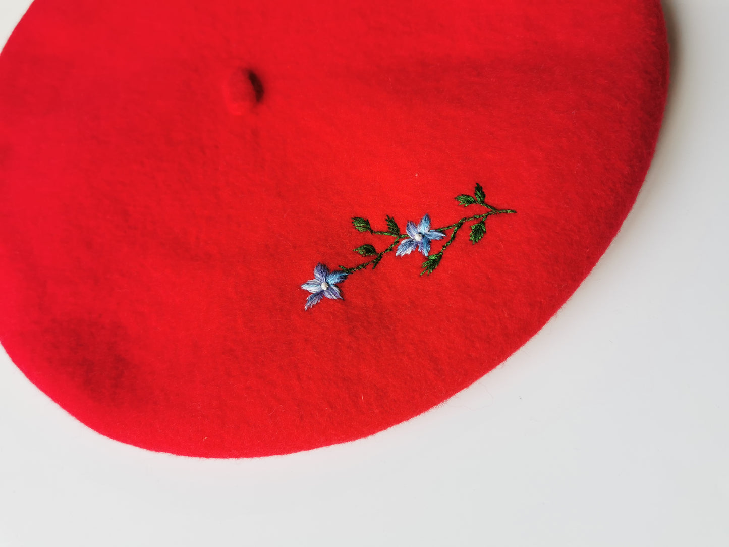 Beretă de lână roşie cu ramură de flori